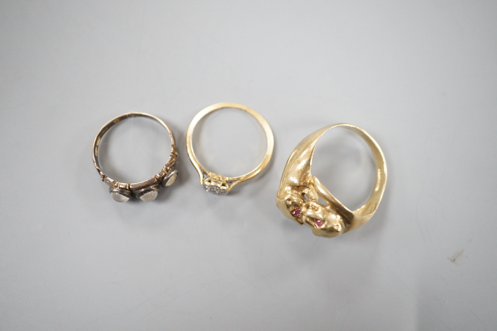 A modern 9ct gold and gem set twin leopards head ring, size S, gross 5.6 grams, a late Victorian 15ct gold and three stone moonstone ring, size M/N (shank cut), gross 3.3 grams and an 18ct and diamond cluster ring, size